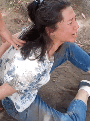 Meilin Kleman, a Falun Dafa practitioner, was injured after being attacked by pro-Beijing individuals who tried to take some of her belongings and stepped on her phone while she tried to film the attacks, in Buenos Aires on Jan. 26, 2025. (A screenshot from a video provided to the Brazil edition of The Epoch Times)