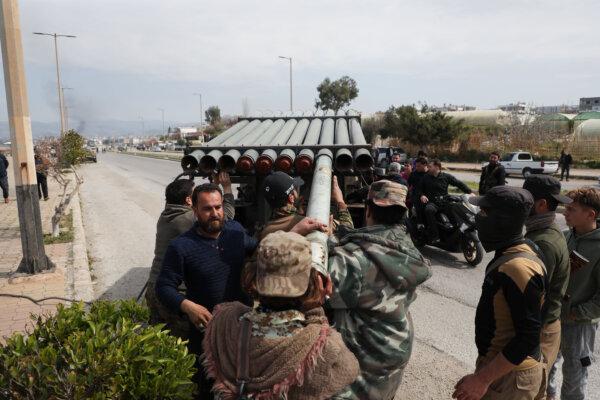 Fighters with the new Syrian government load a rocket launcher in Baniyas, Syria, on March 7, 2025. (Ali Haj Suleiman/Getty Images)