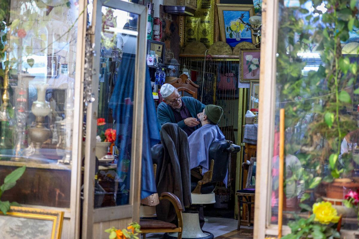 A Palestinian barber tends to a client in the old city of Nablus, in the occupied West Bank, on March 13, 2025. (Zain Jaafar/AFP via Getty Images)
