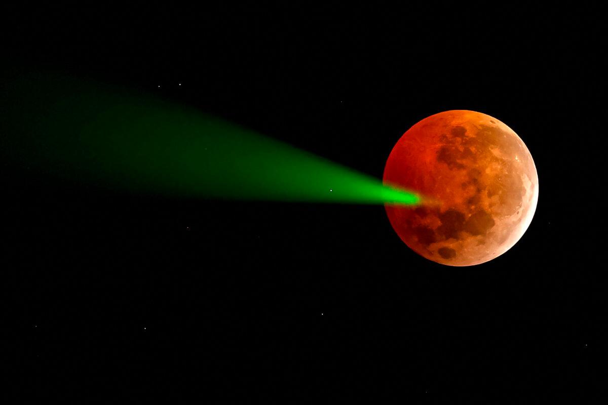 The full moon eclipse is targeted with a laser from the Foster Observatory telescope in Santiago, Chile, on March 14, 2025. (Javier Torres/AFP via Getty Images)
