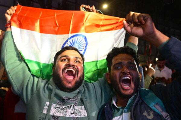 Indian cricket fans hold their national flag along a street in Chandigarh on March 9, 2025, during celebrations after team India's win against New Zealand at the final cricket match in Dubai. (AFP via Getty Images)