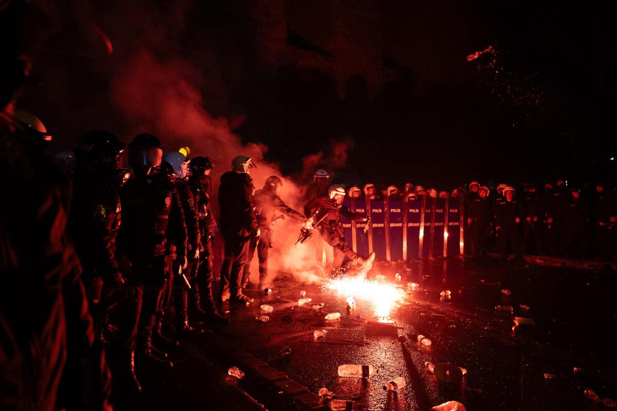 Turkish riot police officers kick back a flare thrown by protesters during clashes at a demonstration near city hall in Istanbul on March 21, 2025. (Ozan Kose/AFP via Getty Images)