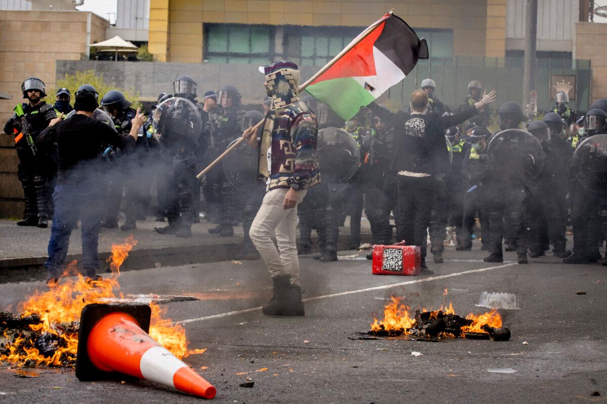 A man waves a Palestinian flag in front of police officers during protests and blockades aimed at disrupting the Land Forces International Defence Expo on Spencer Street in Melbourne, Australia on Sept. 11, 2024. (Darrian Traynor/Getty Images)