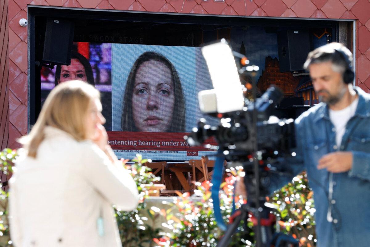 Members of the media work near a large screen showing a picture of convicted hospital nurse Lucy Letby, ahead of her sentencing, outside Manchester Crown Court, in Manchester, England, on Aug. 21, 2023. (Phil Noble/Reuters)