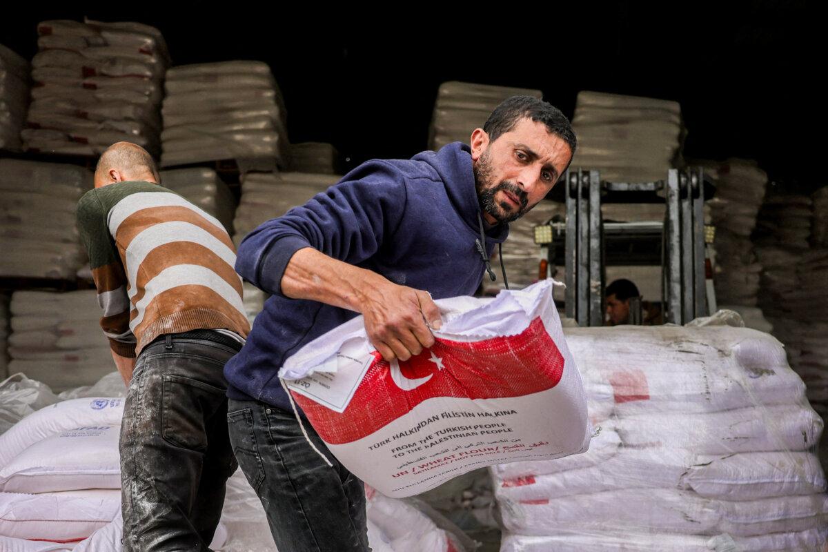 People receive sacks of flour provided by the Turkish disaster relief agency AFAD in the al-Tifah neighborhood of Gaza City on April 1, 2025. (Bashar Taleb/AFP via Getty Images)