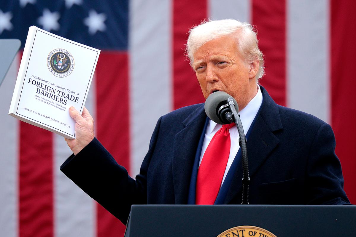 President Donald Trump holds up a copy of a 2025 National Trade Estimate Report as he speaks during a “Make America Wealthy Again” trade announcement event in the Rose Garden at the White House on April 2, 2025. (Chip Somodevilla/Getty Images)