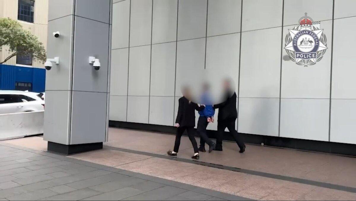 Australian Federal Police officers escort a 15-year-old, alleged to have used online services to recruit killers overseas, to a waiting car. (Courtesy of the AFP)