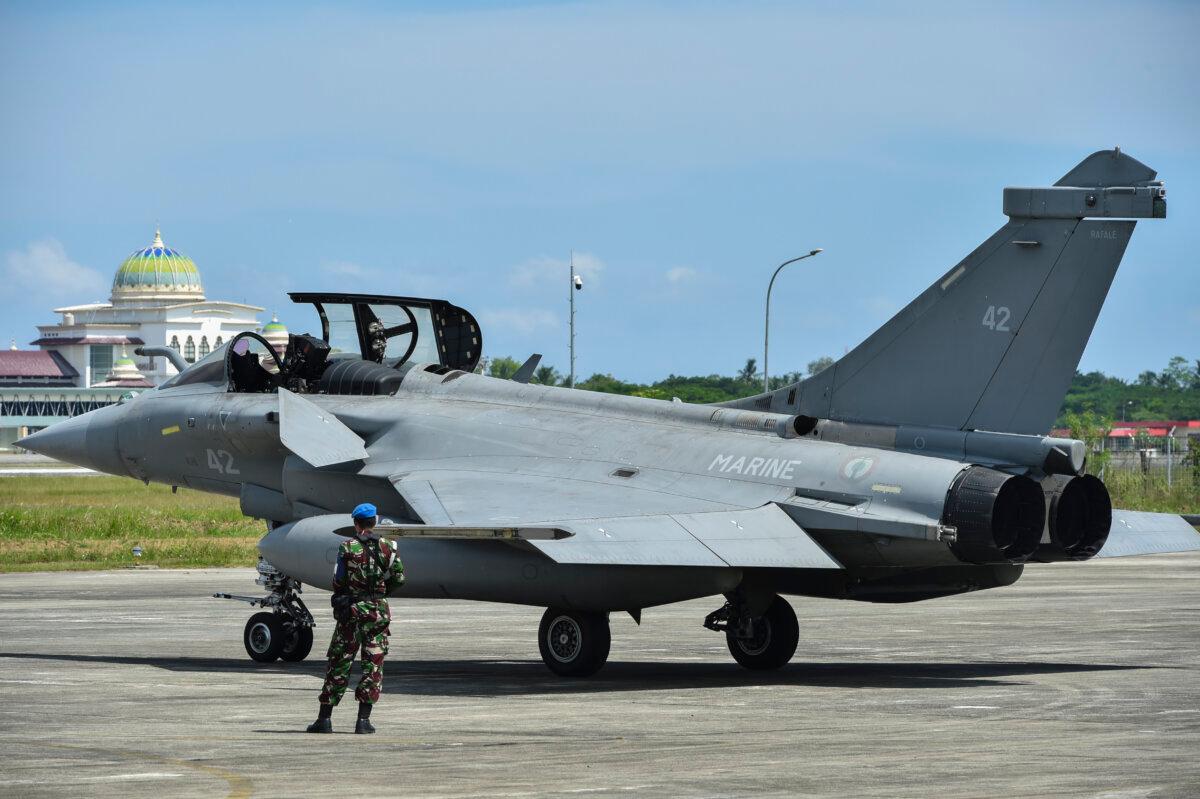 An Indonesian soldier stands guard near a fighter jet at an air force base in Blang Bintang, Indonesia, on May 19, 2019. (Chaideer Mahyuddin/AFP via Getty Images)