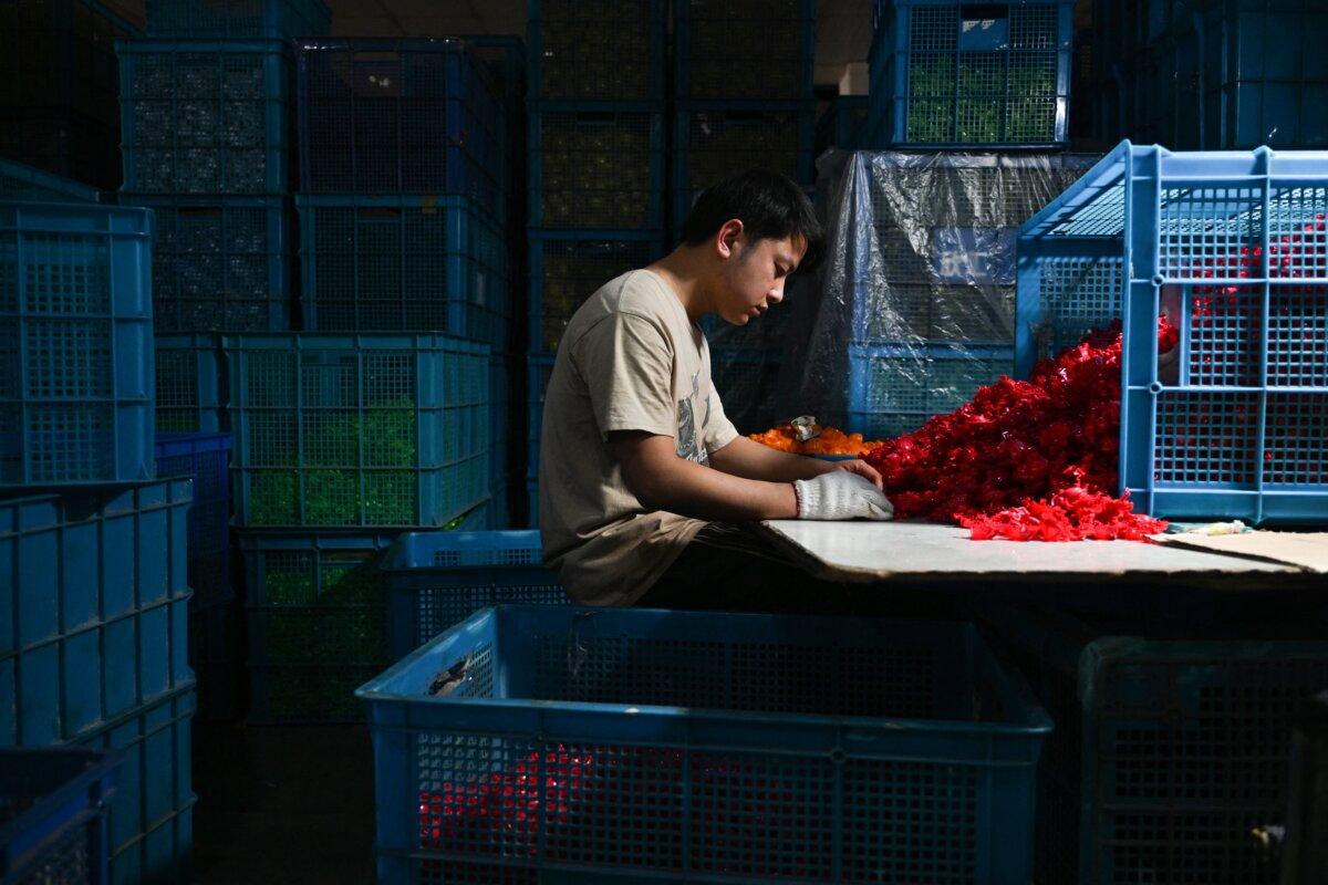 An employee works at a toy factory specializing in solar-powered plastic gadgets in Yiwu, China's eastern Zhejiang province, on April 11, 2025. (Adek Berry/AFP via Getty Images)
