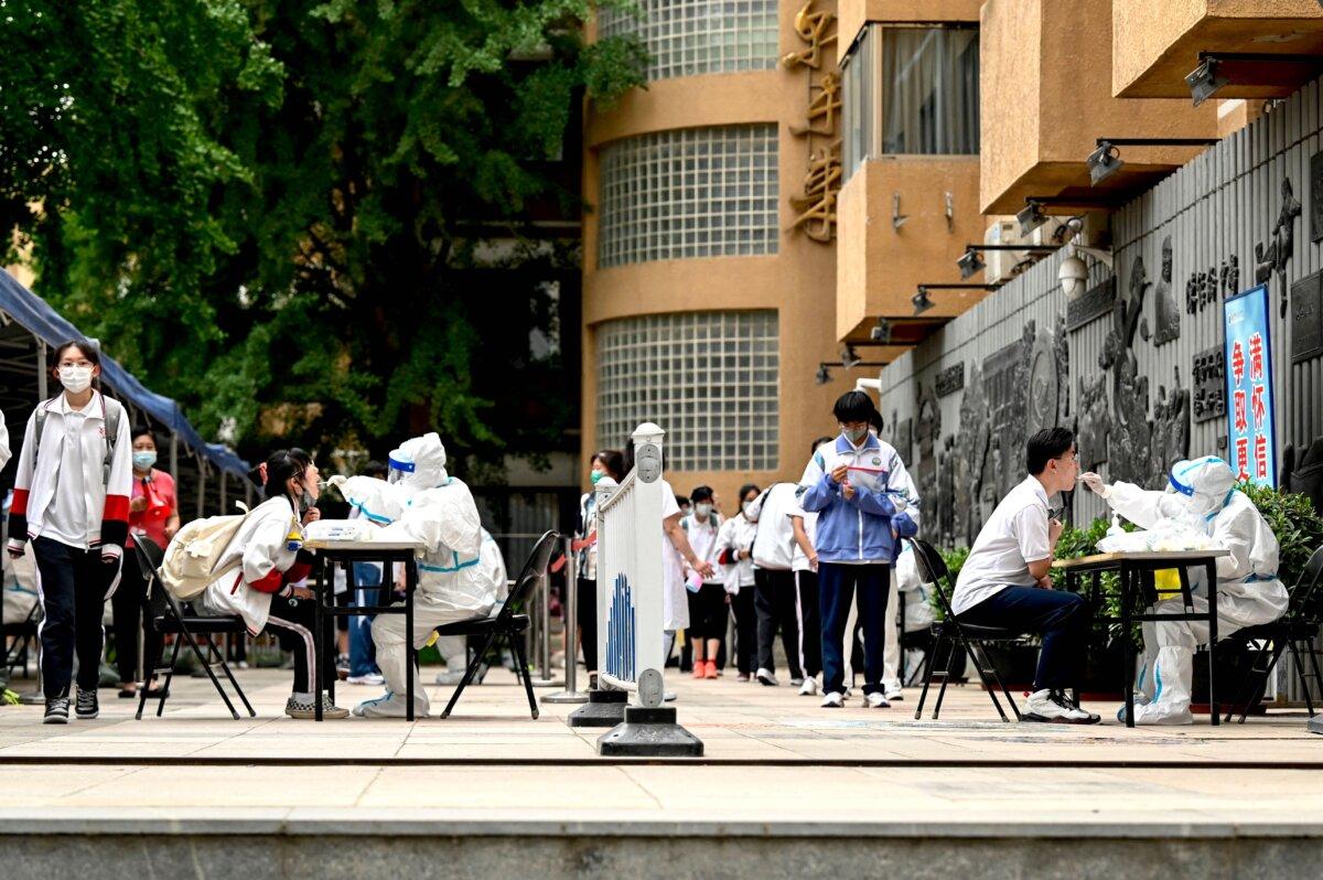 Health workers take swab samples from students to be tested for COVID-19 in Beijing on June 7, 2022. (Jade Gao/AFP via Getty Images)
