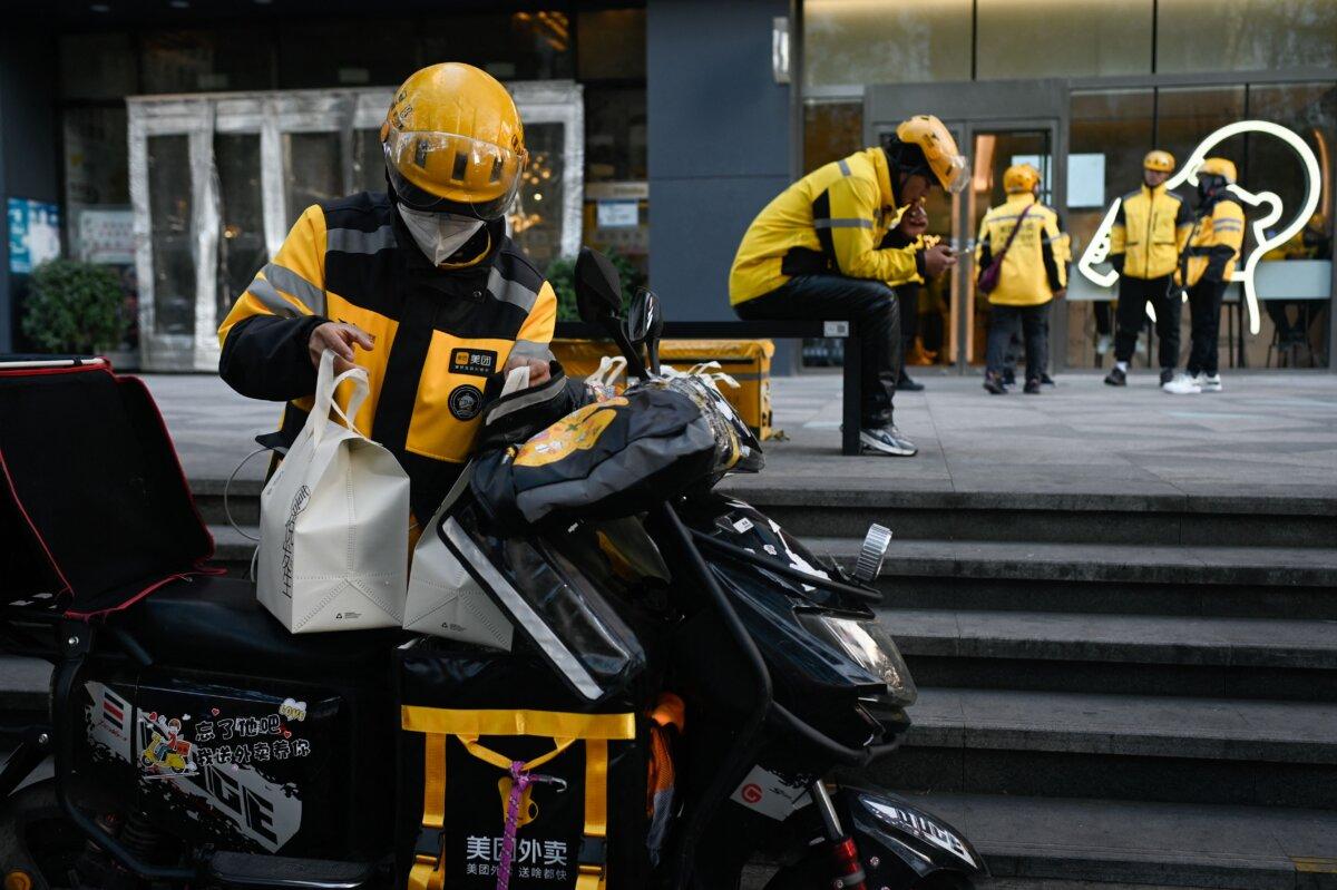 A group of delivery men of Meituan prepare to deliver food in Beijing on Nov. 16, 2023. (Wang Zhao/AFP via Getty Images)