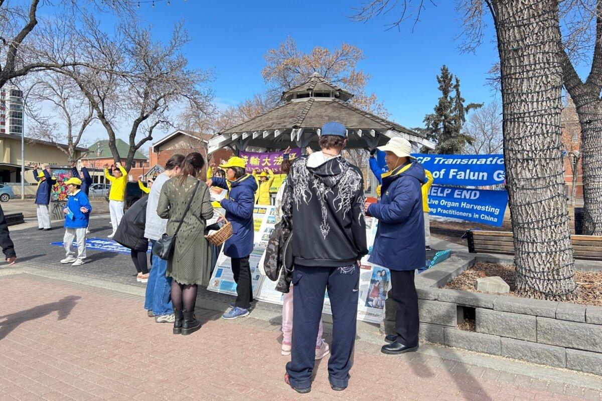 Falun Gong practitioners speak to passersby about their spiritual practice and its persecution by the Chinese regime at an event at Dr. Wilbert McIntyre Park in Edmonton on April 17, 2026, to commemorate the 27th anniversary of their fellow practitioners’ April 25, 1999, appeal in Beijing calling for freedom of belief. (The Epoch Times)