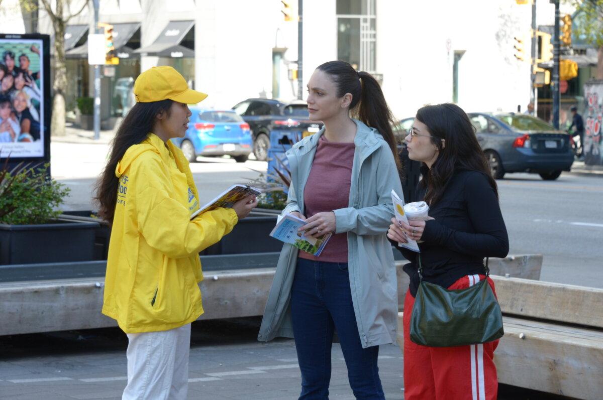 A Falun Gong practitioner speaks to passersby in downtown Vancouver about her spiritual practice and its persecution by the Chinese regime on April 25, 2026, during an event at the Vancouver Art Gallery to commemorate the 27th anniversary of Falun Gong practitioners’ April 25, 1999, appeal in Beijing calling for freedom of belief. (The Epoch Times)