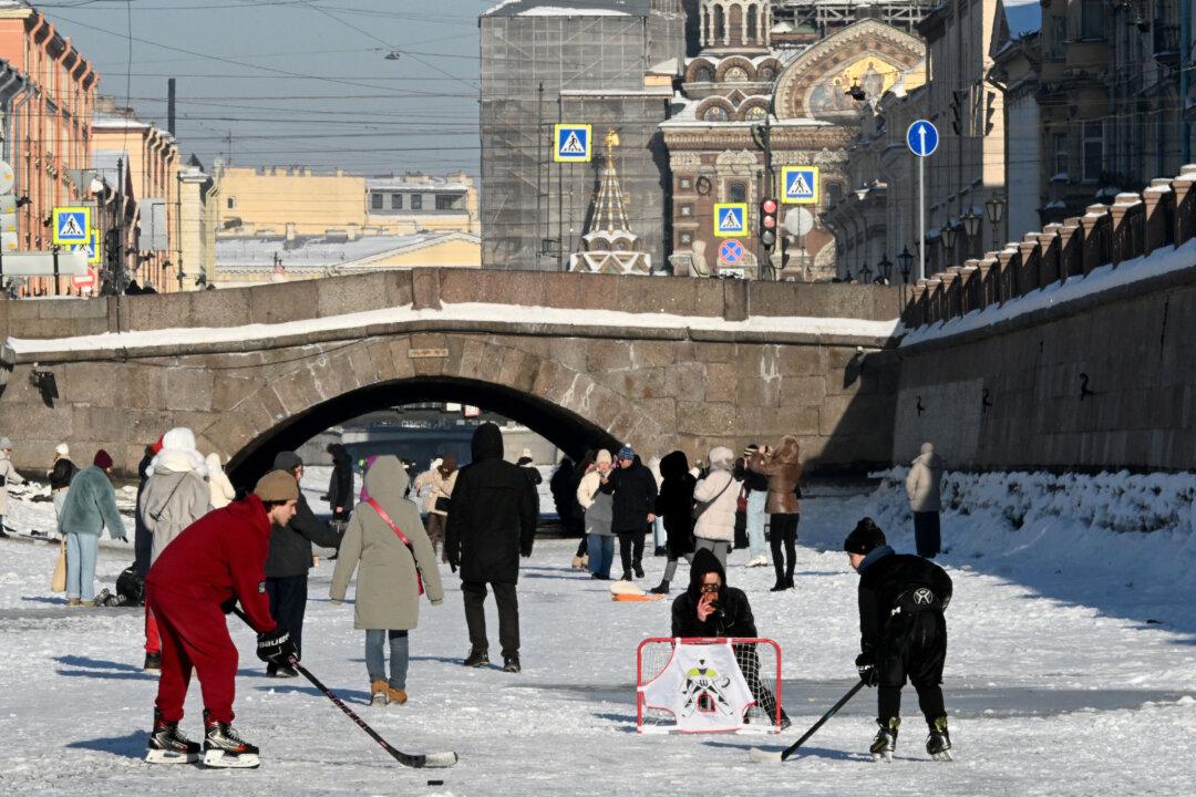 People walk on the frozen Griboyedov Canal in Saint Petersburg on February 6, 2026. (Photo by Olga MALTSEVA / AFP via Getty Images)