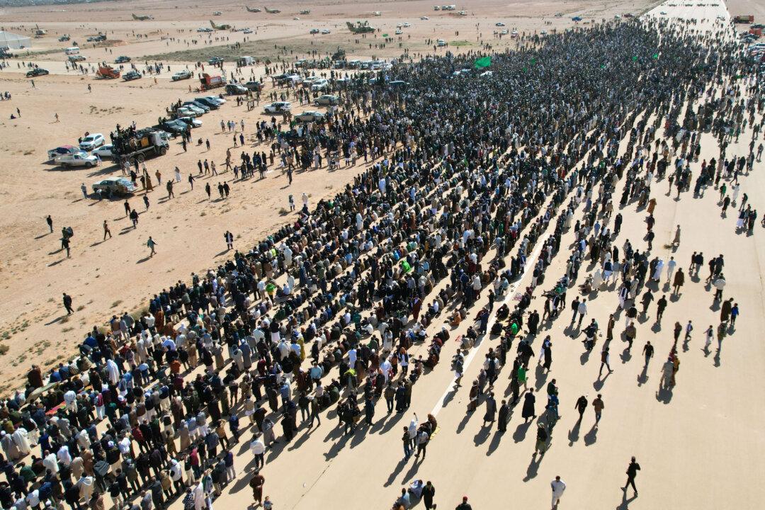 TOPSHOT - This aerial picture shows Libyans gathered for the funeral of Seif al-Islam Gaddafi, the son of Libya's late longtime ruler, in Bani Walid, in the Tripoli region, western Libya on February 6, 2026. Seif al-Islam, 53, the son of Libya's late longtime ruler, had been seen by some as his father's successor, despite being targeted by a warrant from the International Criminal Court for alleged crimes against humanity. He was killed on February 3, 2026, by gunmen who stormed his home in western Libya's Zintan, his French lawyer told AFP. (Photo by Mahmud Turkia / AFP via Getty Images)