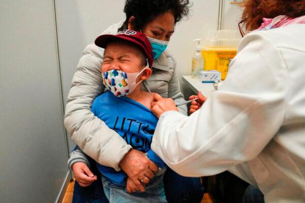 A boy receives a dose of China's Sinovac COVID-19 vaccine at a community vaccination center in Hong Kong on Feb. 25, 2022. (Kin Cheung/AP Photo)