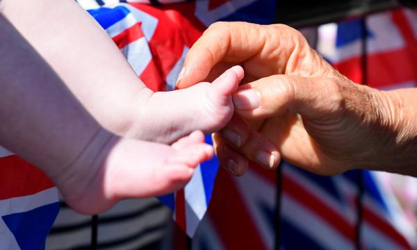 Camilla, then-duchess of Cornwall, tickles a baby's feet as she greets well-wishers during the royal visit to Salisbury, England, on June 22, 2018. (Toby Melville/WPA Pool/Getty Images)