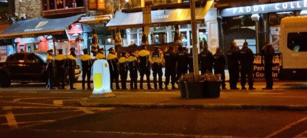 A group of police officers standing in front of Falun Gong demonstrators who were holding banners that read "Falun Dafa is good" and "Stop the persecution of Falun Gong," near a hotel where a Chinese delegation, led by Premier Li Qiang, was staying in Dublin, Ireland, on Jan. 16, 2024. (Irish Falun Dafa Association)