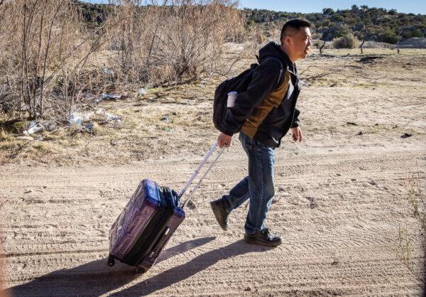 A Chinese national moves toward an opening at the U.S. border wall in Jacumba, Calif., on Dec. 6, 2023. (John Fredricks/The Epoch Times)
