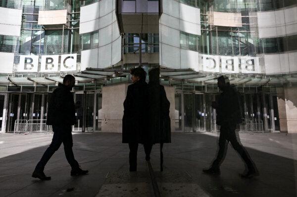 A pedestrian is reflected in the glass facade while walking past the BBC Headquarters at the Broadcasting House in central London on Oct. 6, 2022. (Justin Tallis/AFP via Getty Images)