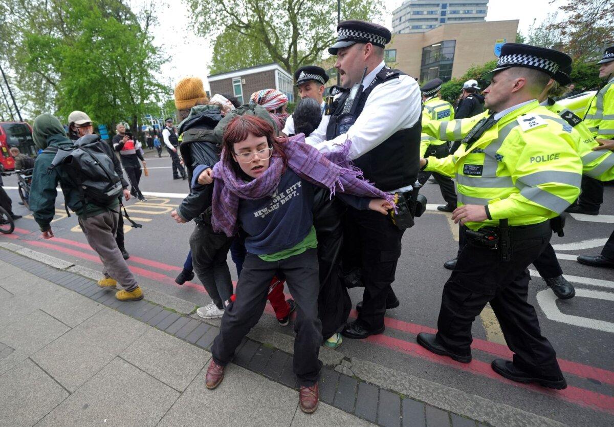 Police officers struggle to contain a demonstration by people opposed to immigrants being taken to the Bibby Stockholm barge outside a hotel in Peckham, south London, on May 2, 2024. (PA)