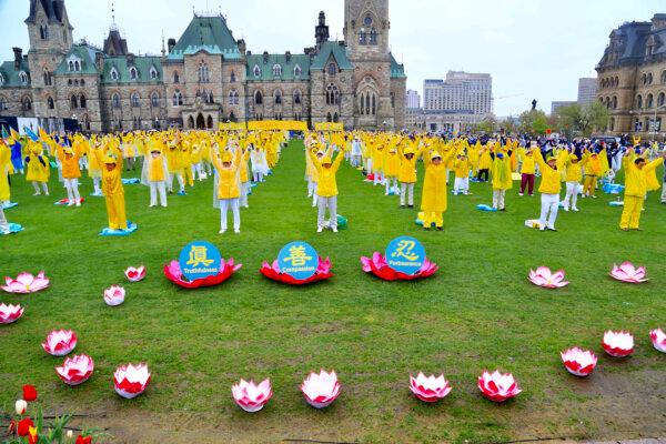 Falun Gong adherents demonstrate a meditative exercise during Falun Dafa Day celebrations on Parliament Hill in Ottawa on May 8, 2024. (Jonathan Ren/The Epoch Times)