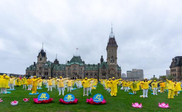Falun Gong adherents demonstrate a meditative exercise during Falun Dafa Day celebrations on Parliament Hill in Ottawa on May 8, 2024. (James Zhou/The Epoch Times)