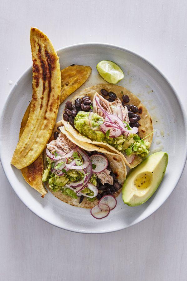 Nestle pulled pork shoulder into warm tortillas with pickled onions, avocado, and spicy tomatillo-lime sauce. (Gentl + Hyers)