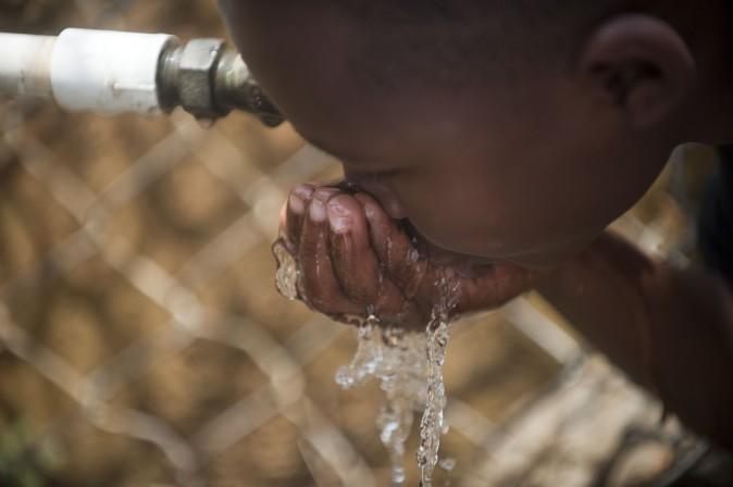 A child drinks water from a public tap. (Raul Arboleda/AFP/Getty Images)