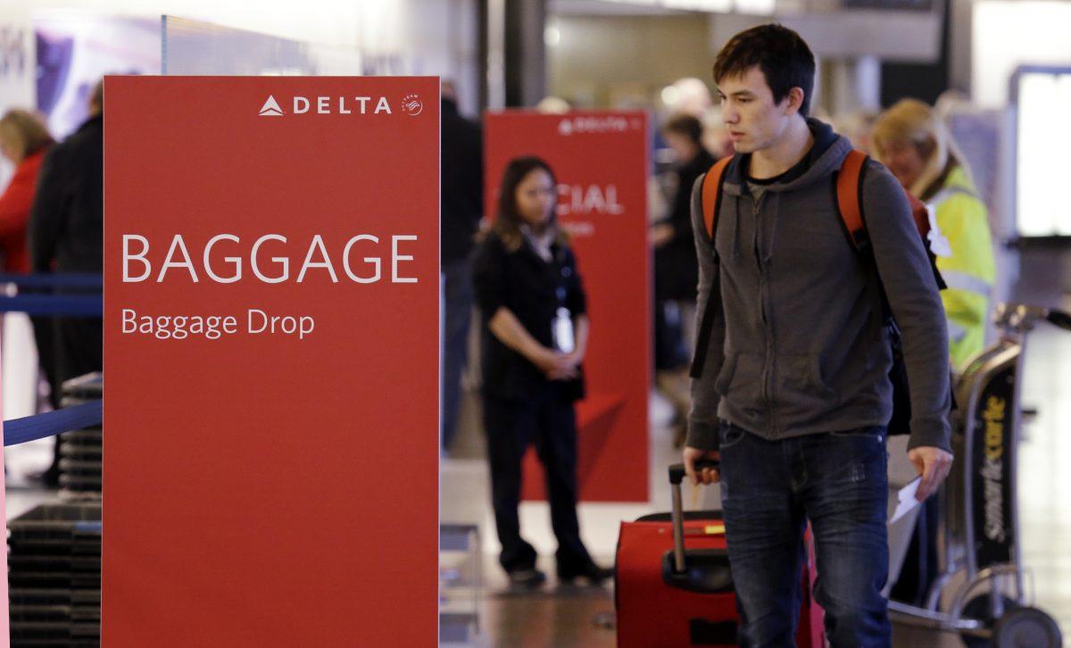 Travelers walk toward the baggage drop area for Delta Air Lines at Seattle-Tacoma International Airport in SeaTac, Wash., on March 24, 2015. (Elaine Thompson)