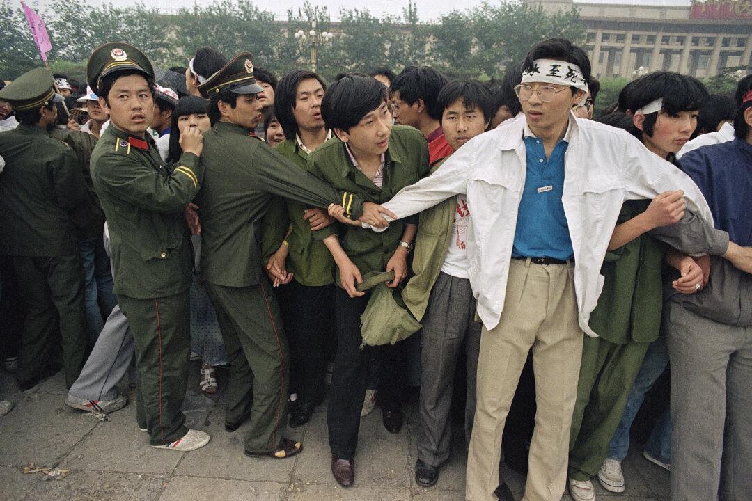 Students and police link arms to keep crowds of people, many of these relatives of strikers, from Tiananmen Square, where students have been on hunger strike since Saturday, Thursday, May 18, 1989, Beijing, China. (AP Photo/Sadayuki Mikami)