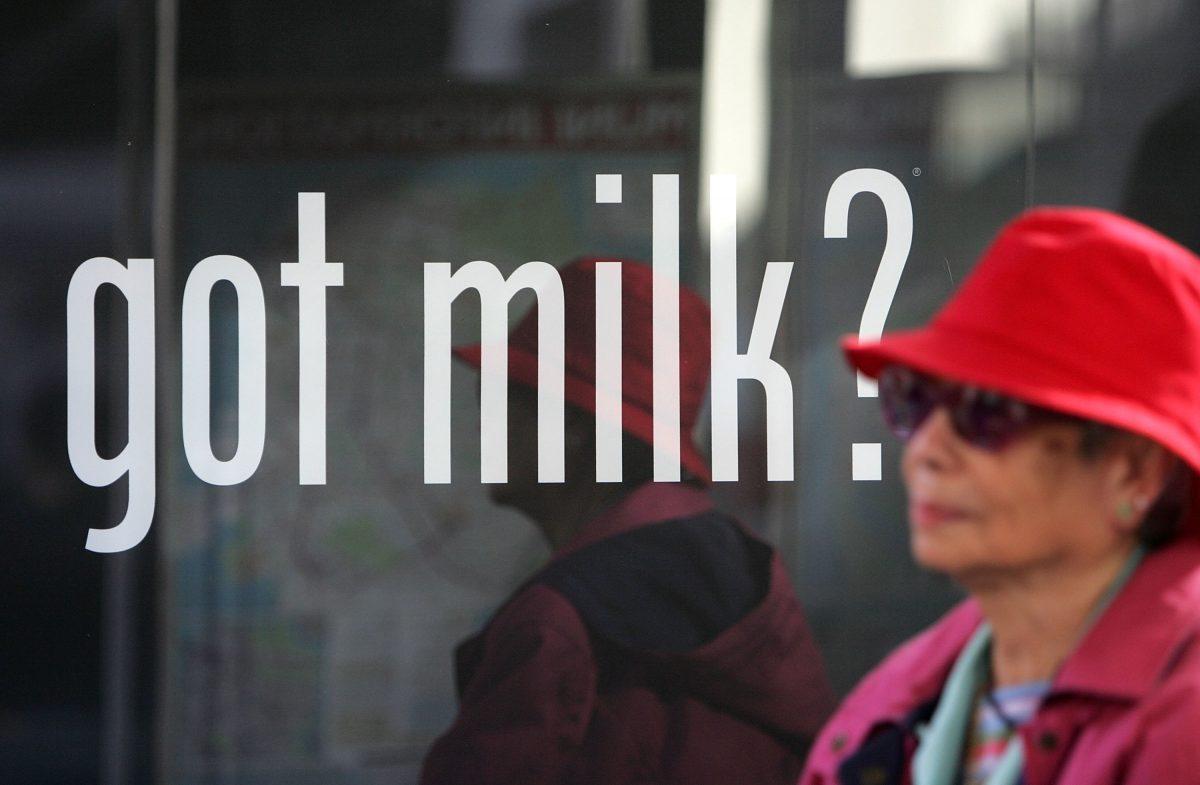 A woman sits next to a milk ad while waiting for a bus in San Francisco on Dec. 4, 2006. (Justin Sullivan/Getty Images)