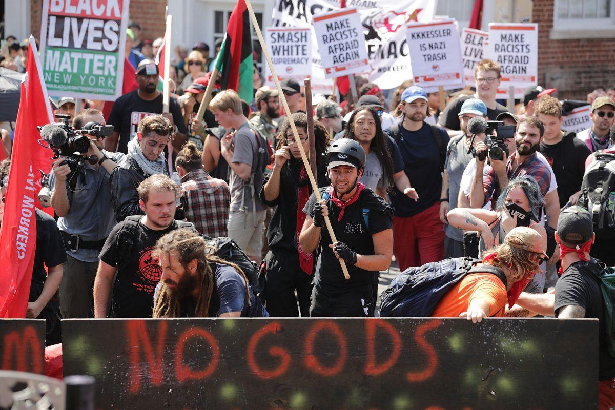 Protesters, including members of the communist extremist group Antifa, hold signs during a protest in Charlottesville, Va., on Aug. 12, 2017. (Chip Somodevilla/Getty Images)