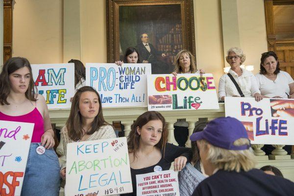 Pro-abortion rights and anti-abortion demonstrators displaying their signs in the lobby of the Georgia State Capitol building during the 35th legislative day at the Georgia State Capitol building in downtown Atlanta, on March 22, 2019. (Alyssa Pointer/Atlanta Journal-Constitution via AP Photo)