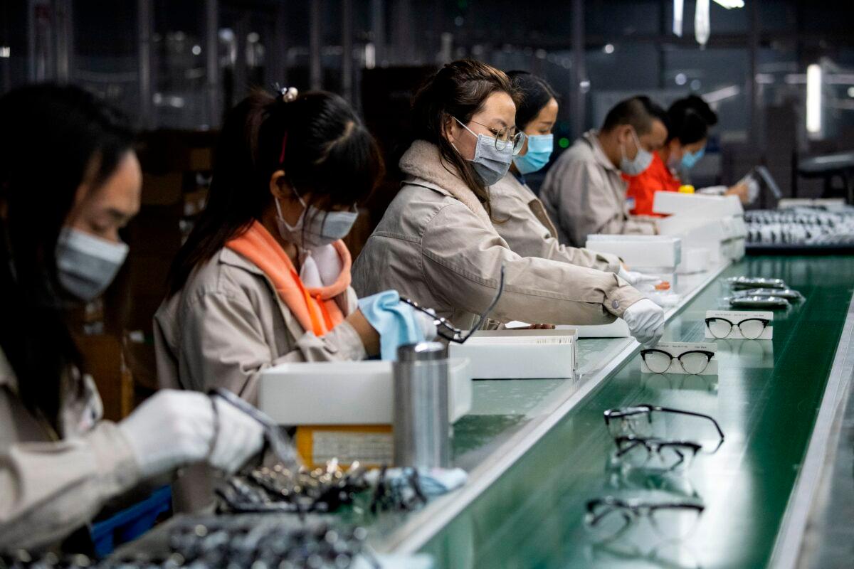 Workers wear face masks as they polish eyeglass frames at the Azure Eyeglasses Co. in Wenzhou, China, on Feb. 28, 2020. (Noel Celis/AFP via Getty Images)