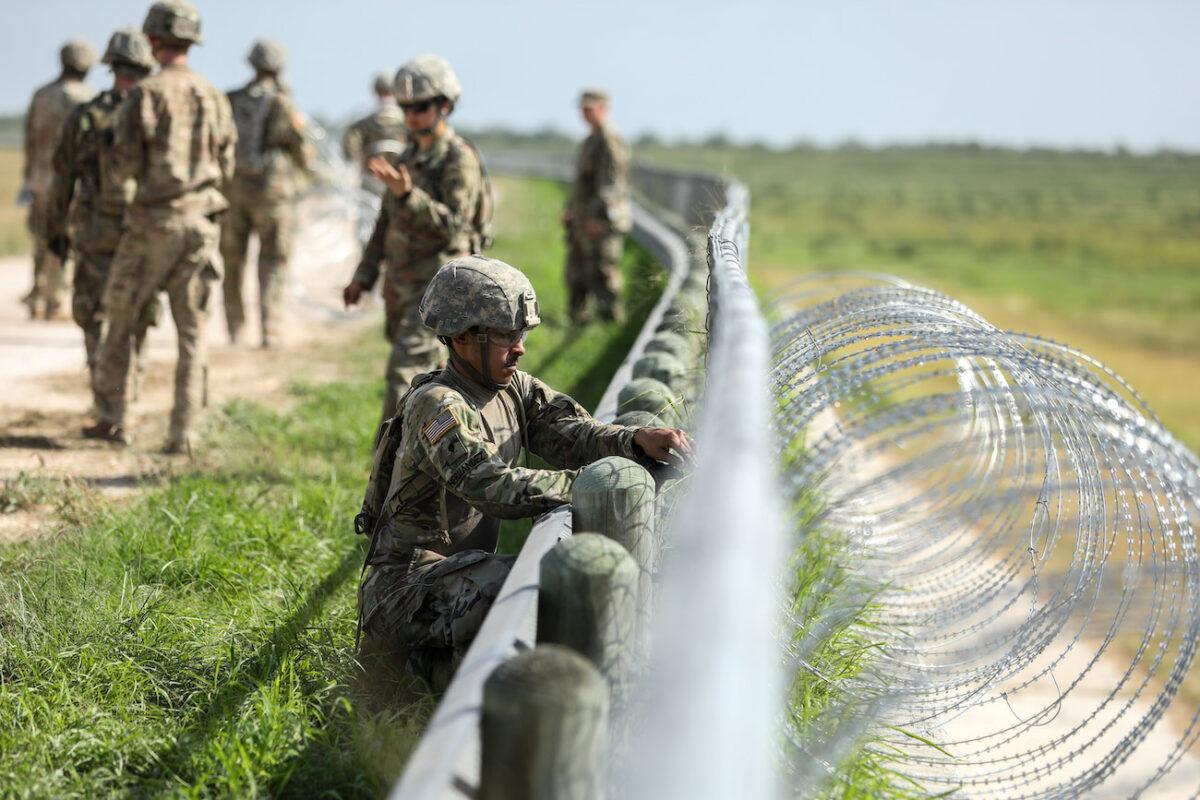 The U.S. military installs concertina wire on the levee behind Granjeno in Texas, just north of the U.S.–Mexico border, on Nov. 7, 2018. (Samira Bouaou/The Epoch Times)