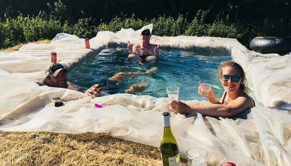 Family Build Makeshift Swimming Pool Out of Hay Bales in Backyard During Heatwave