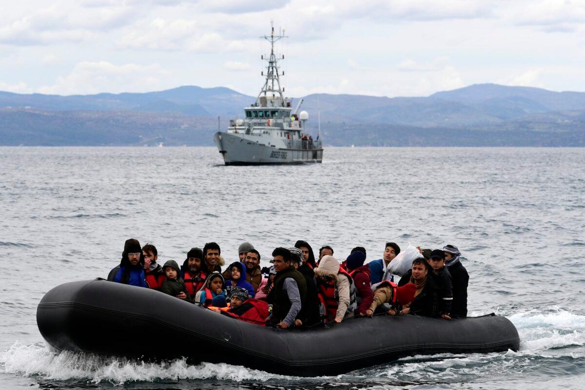 Illegal immigrants arrive in a dinghy accompanied by Frontex vessels at the village of Skala Sikaminias, on the Greek island of Lesbos, after crossing the Aegean Sea from Turkey, on Feb. 28, 2020. (Michael Varaklas/AP Photo)