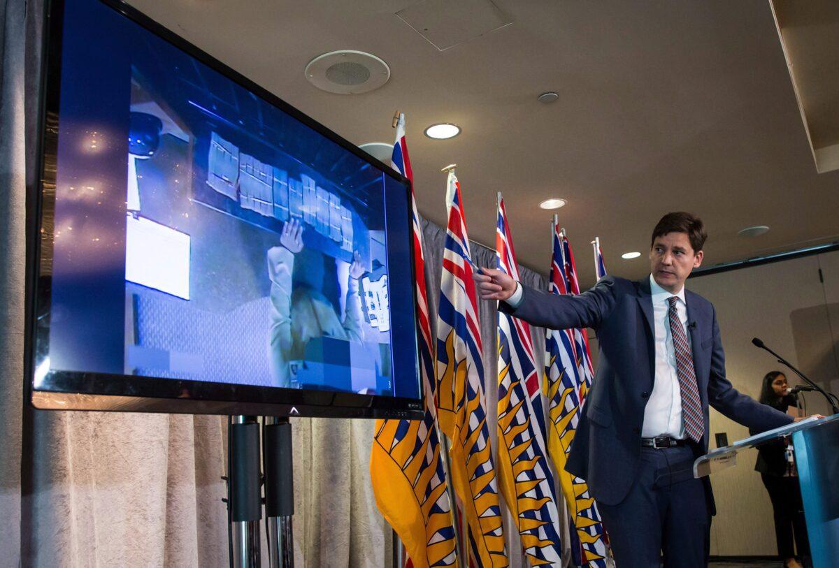 Bundles of cash brought to a casino by an individual are shown on a screen as then-B.C. Attorney General David Eby releases an independent review of anti-money laundering practices in the province’s gambling industry, at a news conference in Vancouver on June 27, 2018. (The Canadian Press/Darryl Dyck)