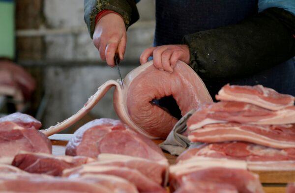A butcher cuts a piece of pork at a market in Beijing, China on March 25, 2016. (Jason Lee/Reuters)