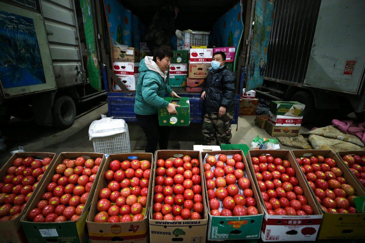 Vendors selling tomatoes wait for customers at a market in Shenyang,Liaoning Province, China, on Dec. 9, 2021. (STR/AFP via Getty Images)