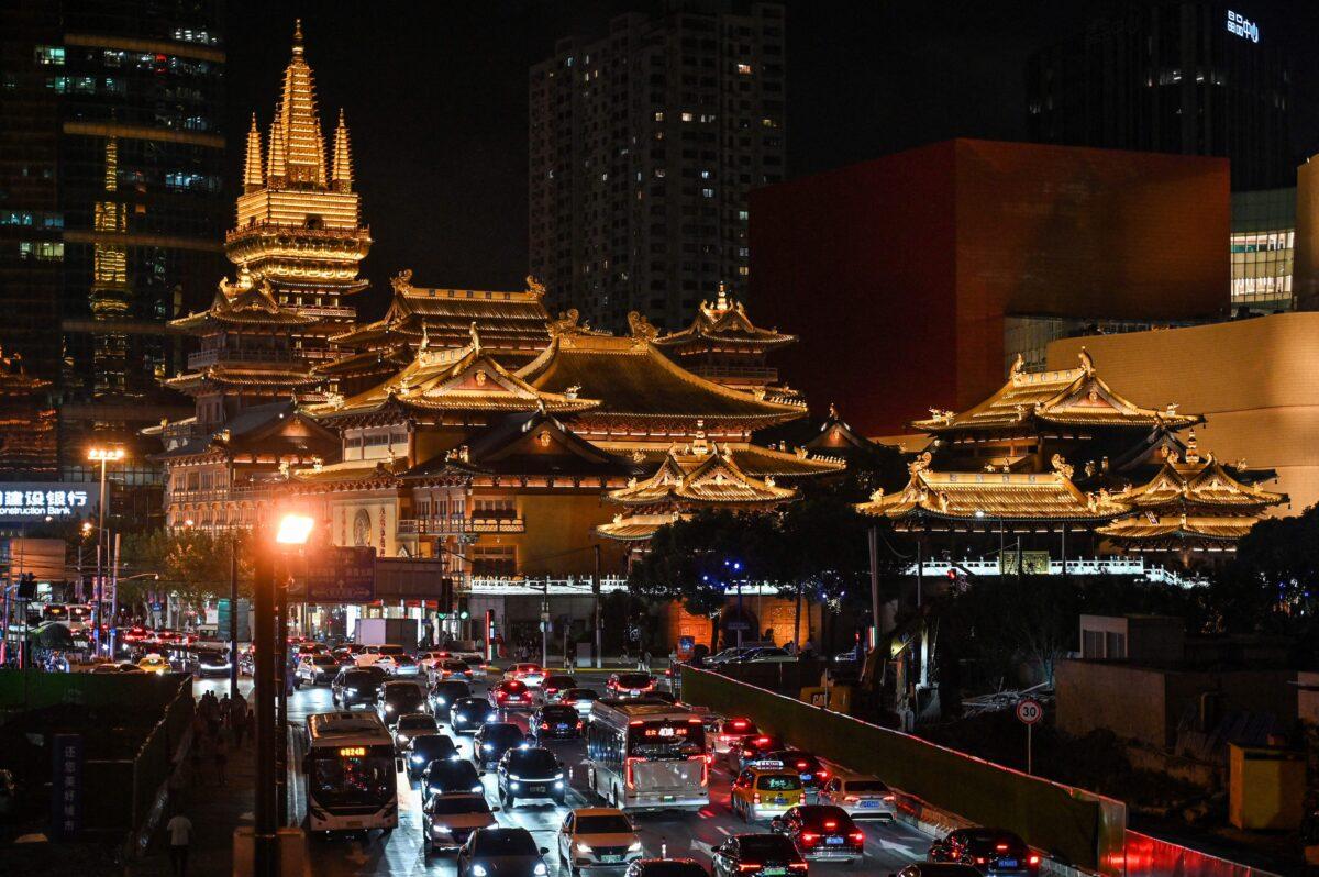 Vehicles make their way along a busy road past the Jing'an Temple in Shanghai on Oct. 14, 2021. (Hector Retamal/AFP via Getty Images)