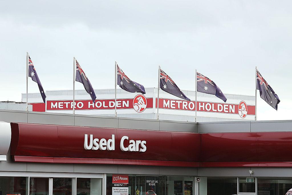 Australian flags fly above a Holden dealership sign in Thebarton in Adelaide, Australia, on July 30, 2013. (Morne de Klerk/Getty Images)