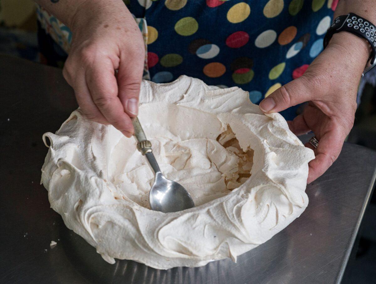 Rachel Swan crushes part of the finished meringue shell to make room for whipped cream in Minneapolis on Monday, April 4, 2022. (Photo courtesy of Richard Tsong-Taatarii/Minneapolis Star Tribune/TNS)