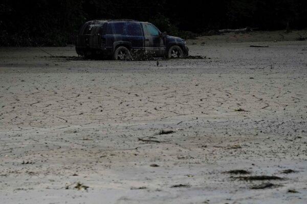 A vehicle is abandoned and surrounded by mud caused by massive flooding near Haddix, Ky., on Aug. 5, 2022. (Brynn Anderson/AP Photo)