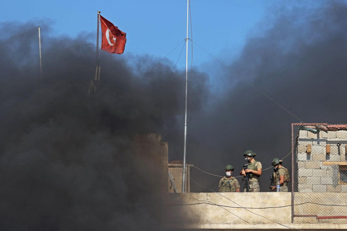 Turkish soldiers stand guard atop an outpost in the village of Balyun in the rebel-held southern countryside of Syria's Idlib Province on July 22, 2021. (Omar Haj Kadour/AFP via Getty Images)