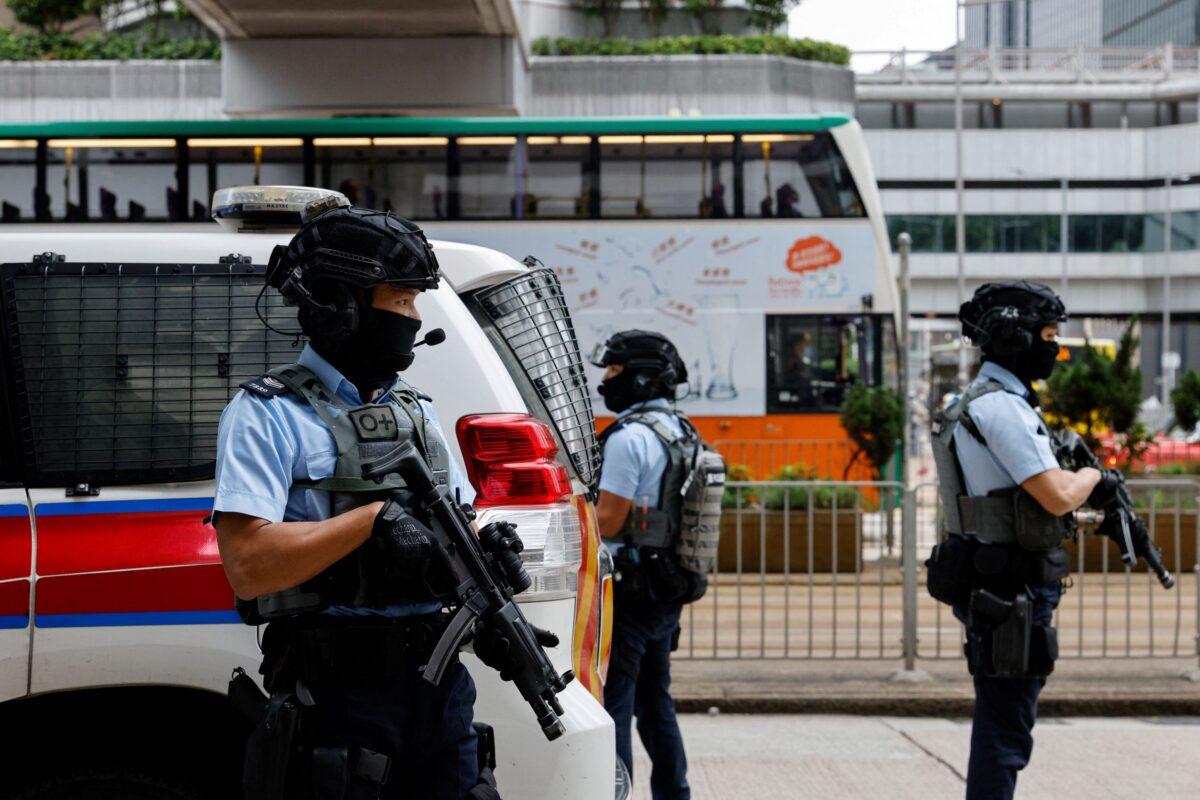 Armed police stand guard as they escort a prison van that is believed to carry media mogul Jimmy Lai, founder of Apple Daily, to the High Court in Hong Kong on Dec. 1, 2022. (Tyrone Siu/Reuters)
