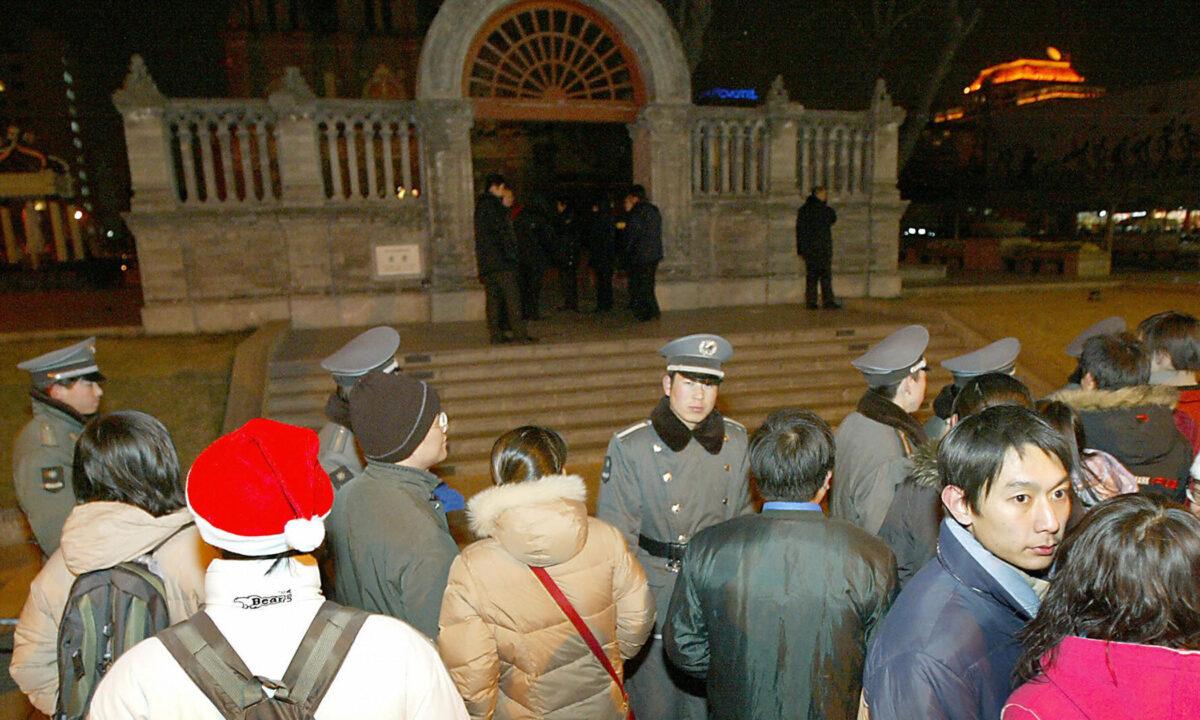 Chinese security guards and police keep hundreds of Chinese Christian worshipers away from the Wangfujing Catholic Church during Christmas mass in Beijing on Dec. 25, 2003. (Goh Chai Hin/AFP via Getty Images)