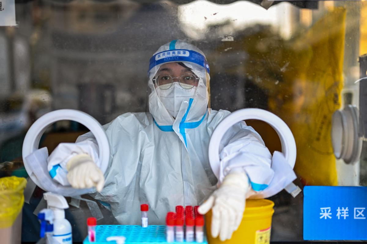 A health worker waits for people to take swab samples to test for COVID-19 in Shanghai, China, on Dec. 19, 2022. Hector Retamal/AFP via Getty Images