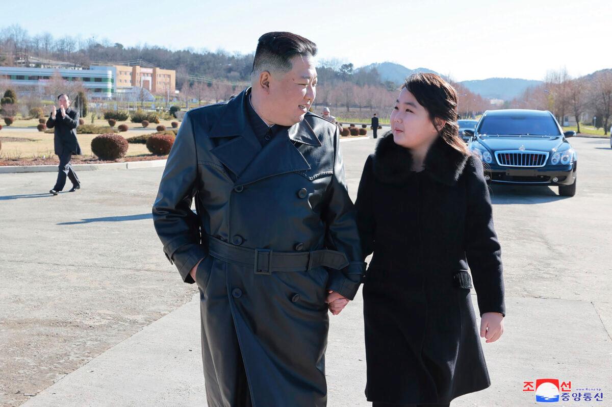 North Korean leader Kim Jong Un and his daughter (R) walk to a photo session with those involved in the recent launch of what it says is a Hwasong-17 intercontinental ballistic missile, at an unidentified location in North Korea in an undated photo provided on Nov. 27, 2022. (Korean Central News Agency/Korea News Service via AP)